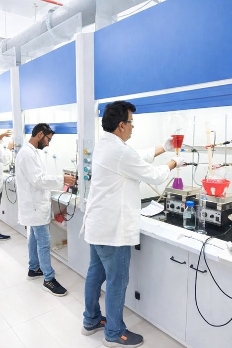 Chemists working at fume hoods